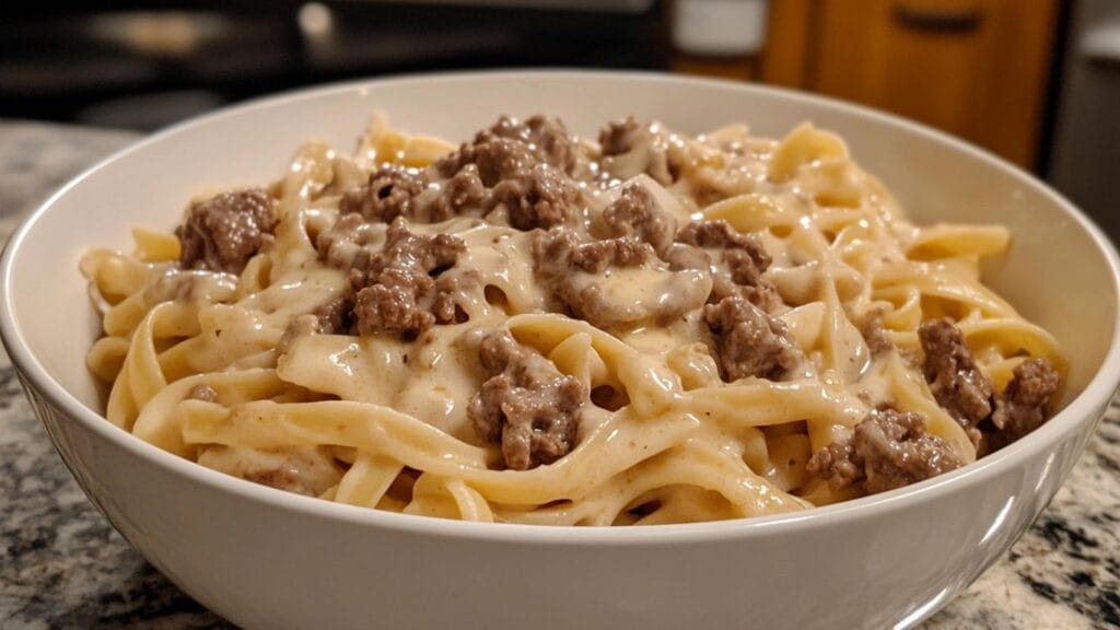 A bowl of creamy Beef Alfredo Pasta with parsley garnish